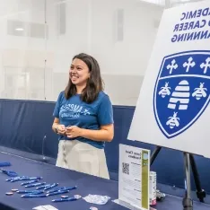 A student standing at a table with a woman at the Career Center.